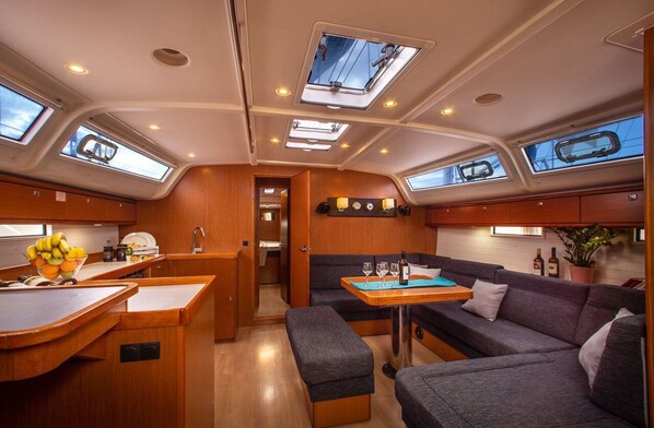 A compact kitchen with a dining area, a seating area, and a small hallway. - Sun-Kissed Sailing Adventure in Islas Sarónicas (Alimos)