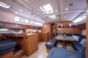 A compact galley with a dining table, seating, and a small kitchenette.