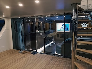 Ein modernes Interieur mit einer Schiebetür zu einer Bar, einer Treppe und einem Fernsehbildschirm.