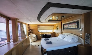 Ein Schlafzimmer mit Bett, Stuhl, Schreibtisch und Fenster.