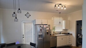 A compact kitchen with a refrigerator, sink, and dining area.