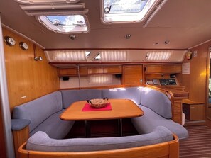 A compact interior with a dining area, a control panel, and a window.