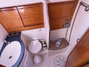 Ein kleines Badezimmer mit Waschbecken, Toilette und Dusche.