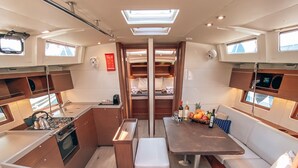 A compact galley with a stove, sink, and storage cabinets. - Sun-Kissed Sailing Adventure in Islas Sarónicas (Alimos)
