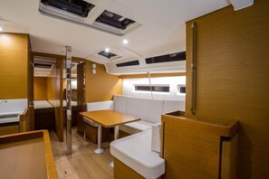 Un intérieur compact et bien éclairé, comprenant un coin salon, une table et une petite kitchenette.
