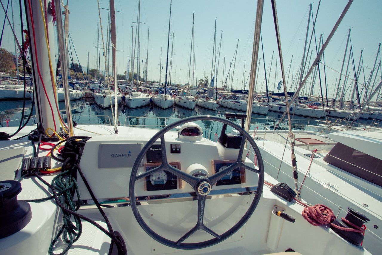 La barre d’un bateau, avec un volant, des panneaux de commande et des cordages.