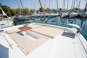 Un port de plaisance où sont amarrés de nombreux bateaux, un ciel dégagé et une surface d’eau calme.