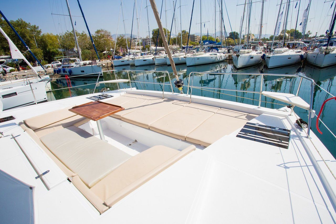 A marina with multiple boats docked, a clear sky, and a calm water surface.