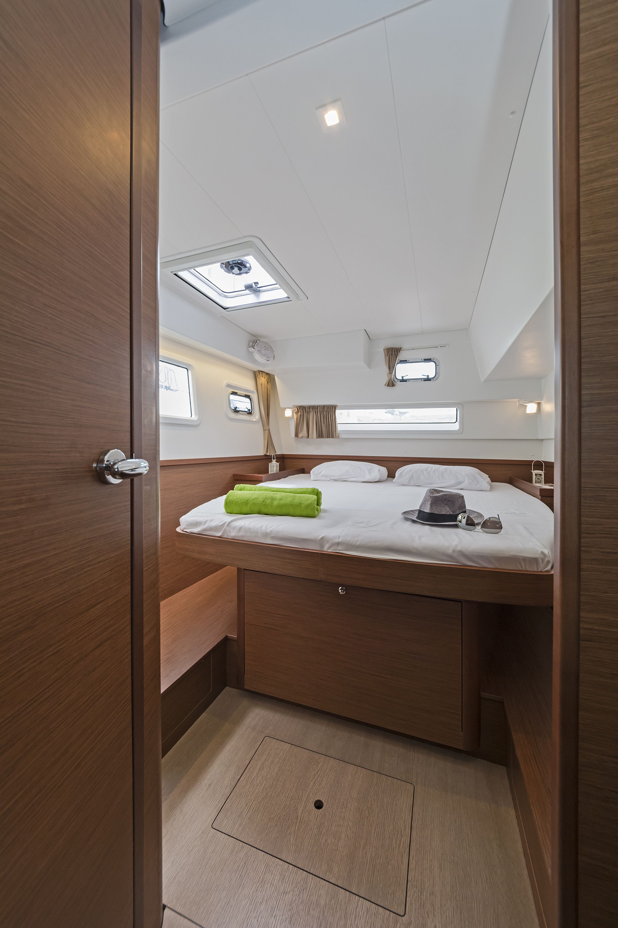A compact bedroom with a bed, a small window, and a skylight.