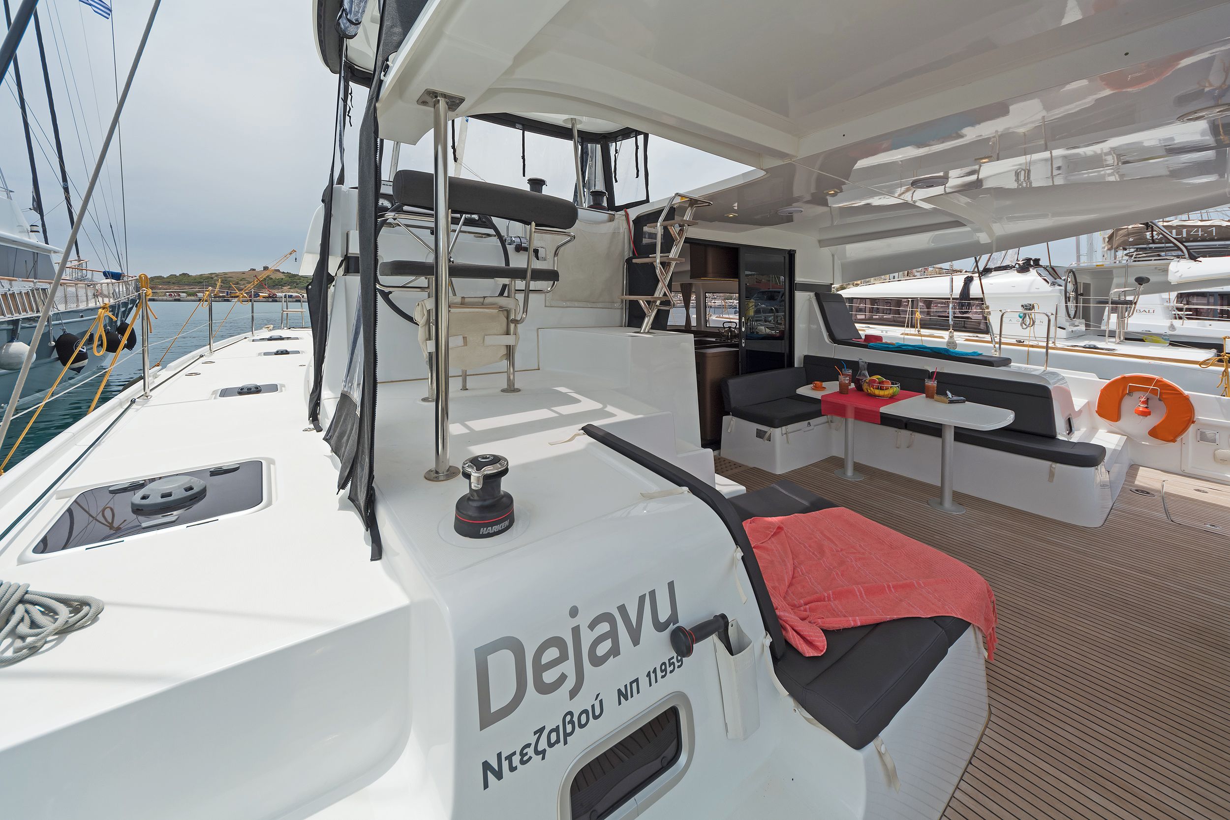 A yacht deck with a seating area, a table, and a life preserver.