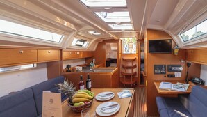 Een compact, goed verlicht interieur met een eethoek, zitplaatsen en een kleine keuken.