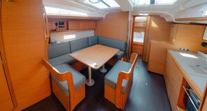 A compact galley with a table and two cushioned seating areas.