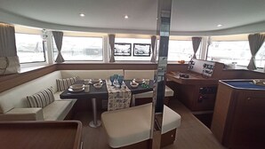 Bootinterieur met een eethoek, keuken en zithoek.