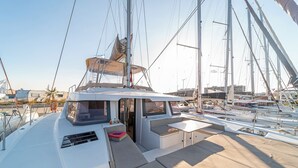 A yacht with a covered deck, seating area, and a window.
