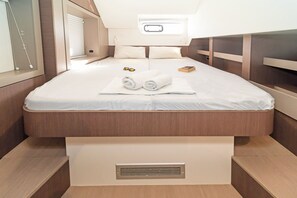 Ein kleines, helles Schlafzimmer mit einem Einzelbett, einem kleinen Fenster und einem eingebauten Lüftungsgitter.