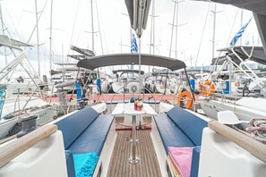 Ein Bootsdeck mit Sitzgelegenheiten, einem Tisch und verschiedenen nautischen Geräten.