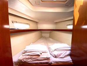 A cabin with two beds, each with neatly folded white linens. - Sun-Kissed Sailing Adventure in Islas Sarónicas (Alimos)