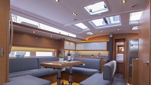 A compact, well-lit interior with a dining area, seating, and a kitchenette. - Sun-kissed Sailing Adventure in the Ionian Islands (Preveza)