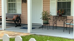 A porch with a bench, a potted plant, a small table, and a chair. - Adorable 1-bedroom barn in Mineola, East Texas also known as Lake Country (Mineola)