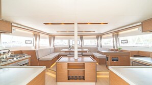 Una cocina moderna con una isla central, zona de estar y ventanas amplias.