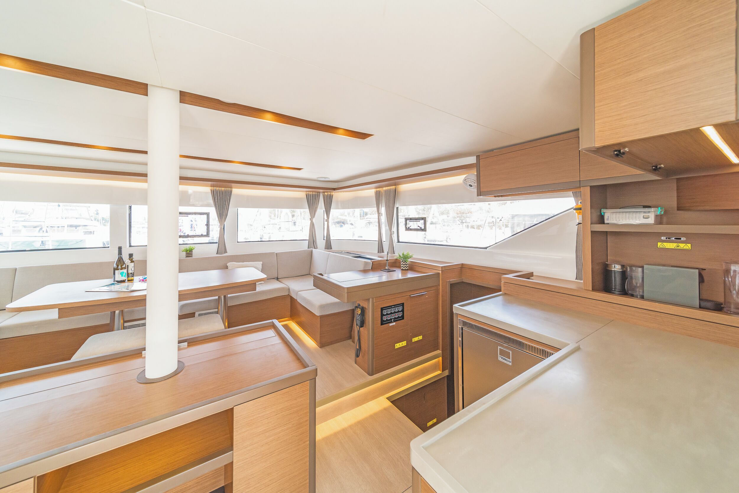 A modern interior with a kitchen area, seating, and a view through the windows.