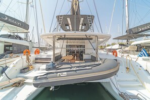 Eine Yacht mit überdectem Deck, Sitzgelegenheiten und einem kleinen Tisch.