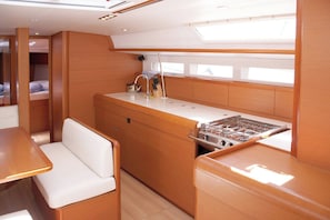 A compact galley with a stove, sink, and seating area.