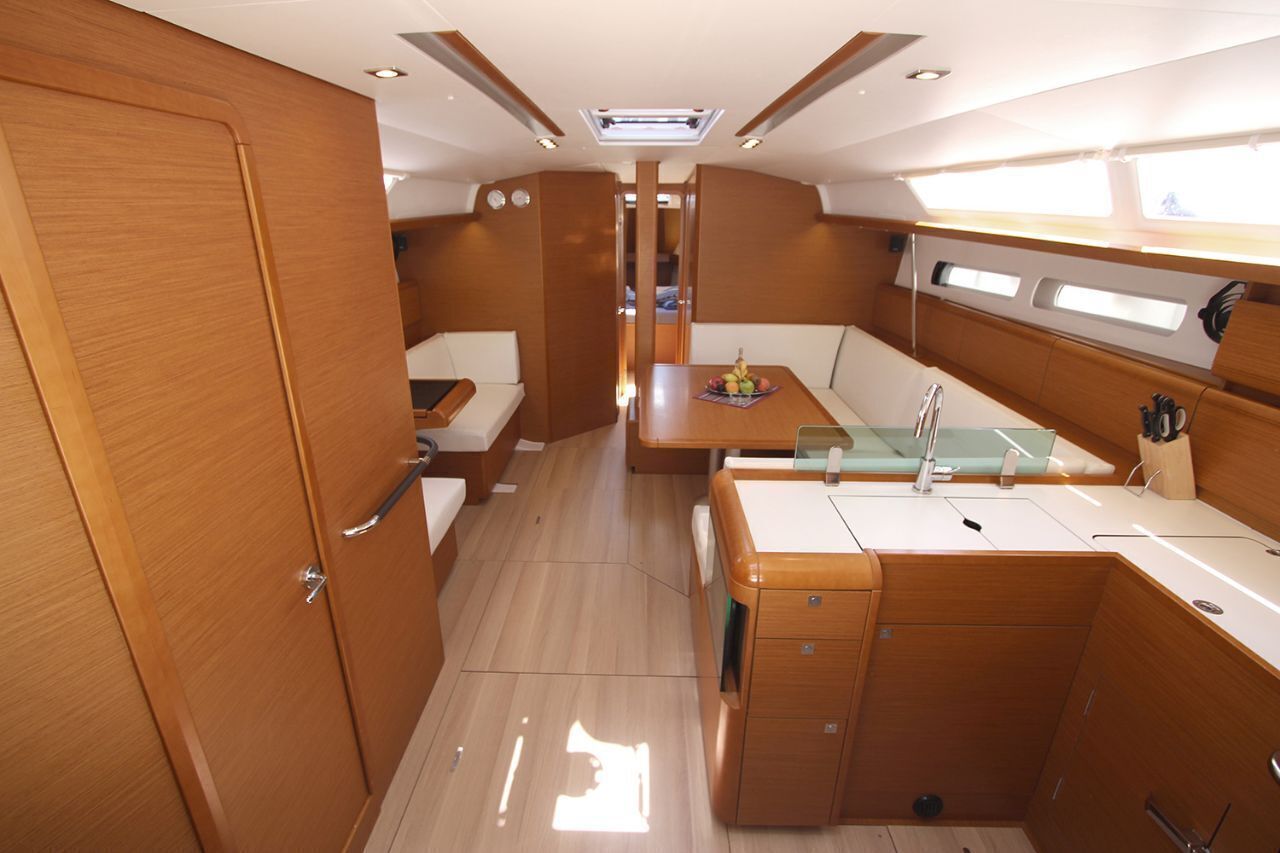 A compact interior with a kitchenette, seating area, and a wooden door.