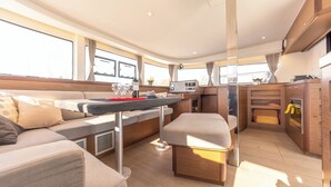 Un espacio habitable compacto con sofá, una pequeña mesa, kitchenette y una ventana que proporciona luz natural.