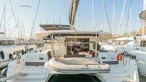 Un puerto deportivo con varias embarcaciones amarradas, que incluye una cabaña con comedor y una terraza cubierta.