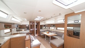 Een modern camperinterieur met keuken, eethoek en zitplaatsen.