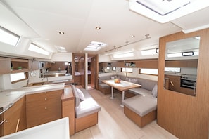 Ein modernes Wohnmobil-Interieur mit Küche, Essbereich und Sitzgelegenheiten.