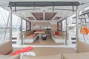 Schiffsinnenraum mit Essbereich, Sitzgelegenheiten und Blick auf den Hafen.