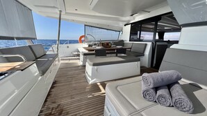 En lyxig inredning i en yacht med ett matområde, sittplatser och utsikt över havet.