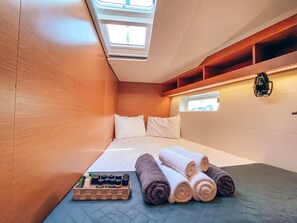 Ein kleines Zimmer mit einem Bett, einem kleinen Fenster und einem Oberlicht.