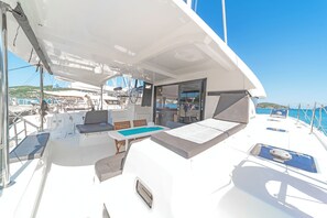 A sunlit deck with a seating area, a small pool, and a view of the sea. - Sun-Kissed Sailing Adventure in the Ionian Islands, Lefkada (Lefkada)