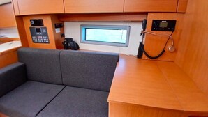 Un intérieur compact avec un canapé gris, une petite table et un panneau de commande doté d’un écran.