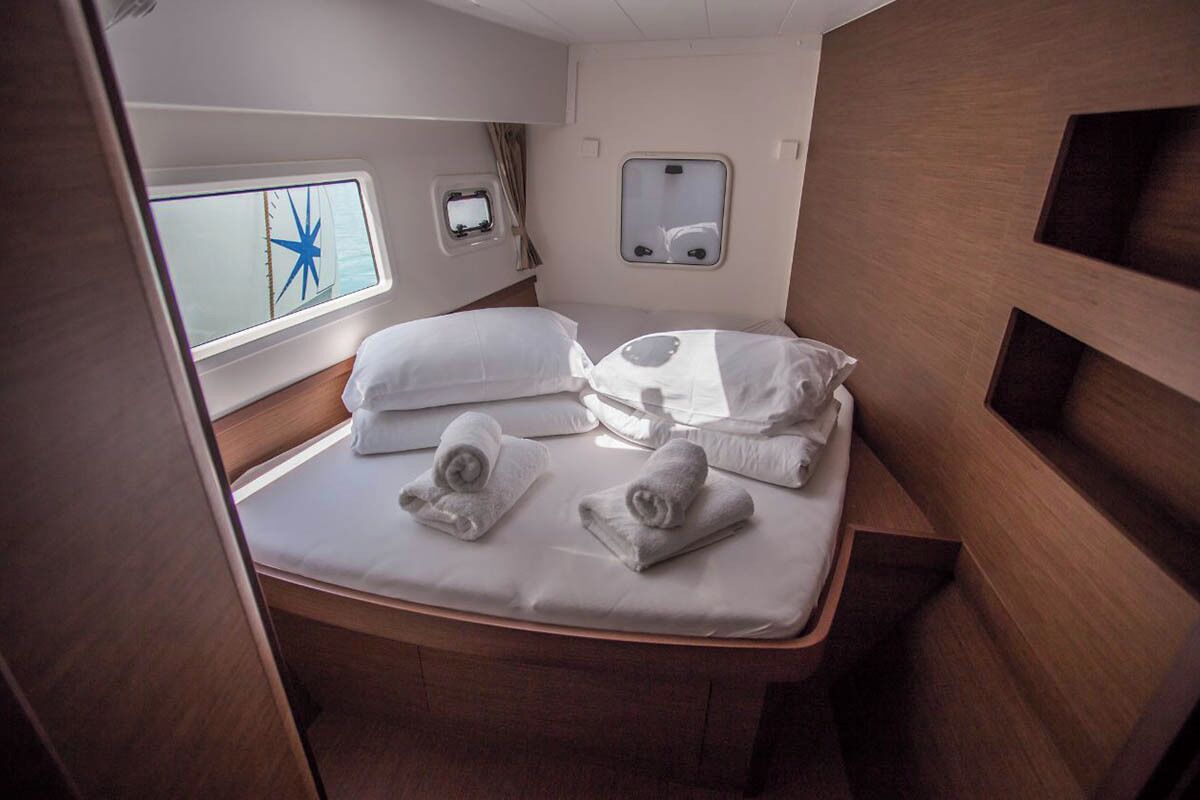 Ein gemütlicher Schlafraum mit Bett, kleinem Fenster und Sterne-Dekoration sowie einem Spiegel.