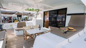 Eine sonnendurchflutete Terrasse mit Tisch, Stühlen und einer gepolsterten Sitzecke.