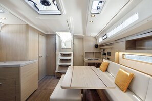 A compact, well-lit interior with a dining area, storage cabinets, and a seating bench. - Sun-Kissed Sailing Adventure in Islas Sarónicas (Alimos)