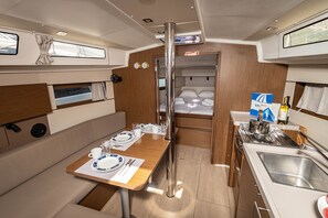 A compact kitchen with a dining area, a small refrigerator, and a sink.