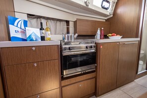 A compact kitchen with wooden cabinets, a stainless steel stove, and a small countertop.