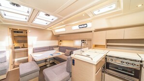 A compact galley with a stove, a small dining table, and seating. - Sun-Kissed Sailing Adventure in the Dodecanese Islands (Kos)