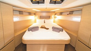 A compact, well-lit bedroom with a single bed, built-in storage, and overhead lighting. - Sun-Kissed Sailing Adventure in the Dodecanese Islands (Kos)