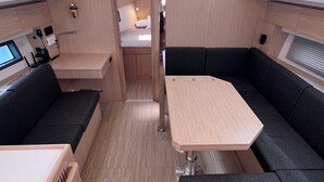 Ein kompaktes Wohnmobil-Interieur mit Essbereich, Sitzgelegenheiten und einer Küchenzeile.