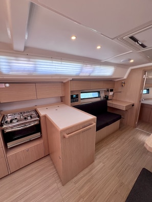 A compact galley with a stove, a small sink, and a seating area.