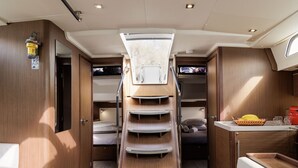 Een compact interieur met een stapelbed, een klein kitchenette en een dakraam.