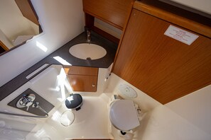 Ein kleines Badezimmer mit Waschbecken, Toilette und Dusche.