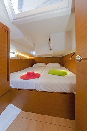 A compact, well-lit cabin with a single bed, a skylight, and a wooden interior. - Sun-Kissed Sailing Adventure in the Saronic Islands (Laurium)
