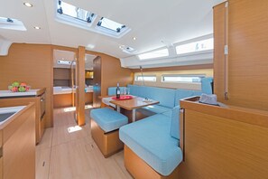 A compact, well-lit interior with a dining area, seating, and a kitchenette.